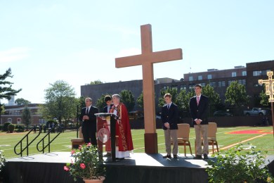 Fr. Garrett Long S.M. '62 reads the homily at the Triumph of the Cross prayer service.