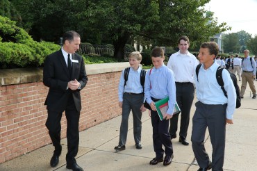 Bro. Thomas Cleary '81 greets new freshman to Chaminade High School along with Senior Leader Colin Maloney '15 (second from right).