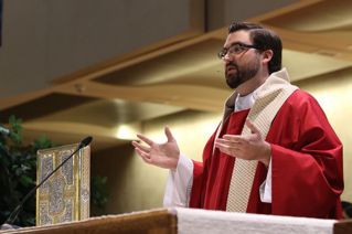 Father Andrew Garnett '06 delivers his homily to the Chaminade student body.