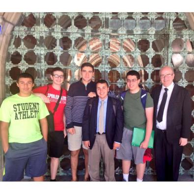 Members of the Speech and Debate Team pose for a photo after John Michael won his octo-final round. 