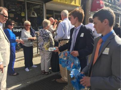 (l.-r.) Clark Newby '17 and Sean Maleady '17 hand out water bottles to thirsty congregants on the long line to enter MSG. 