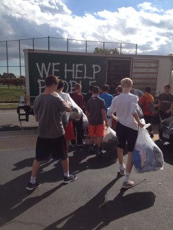Sophomore GSO helps load the clothing donations onto St. Vincent de Paul's iconic truck.