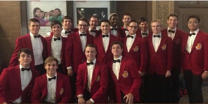 Members of the Vocal Chamber Ensemble, dressed in their signature red jackets and black bow ties, assemble for a group shot in front of Carnegie Hall.