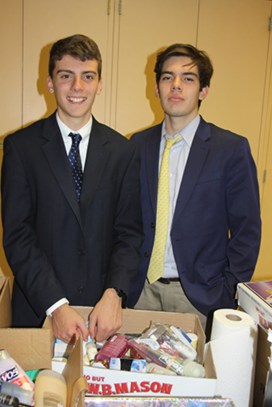(l.-r.) Seniors Sean Galligan and Christian Hurley sort the supplies for delivery to the Queen of Peace Residence. 