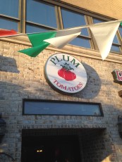 The sign above the door proudly displays the name the Mineola pizzeria, Plum Tomatoes.