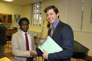 Kenneth Bradley ’18 shakes hands with Mr. Andrew Corcoran ’01 after the judging of the project, “Effects of Iron on the Reproduction of Chlorella Vulgaris”.