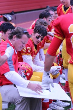 An experienced and well-respected coach, Stephen Boyd draws up a plan during one of this year’s varsity football games. 