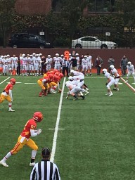 The offense blocks the Fordham Prep defense as a running back rushes the ball.