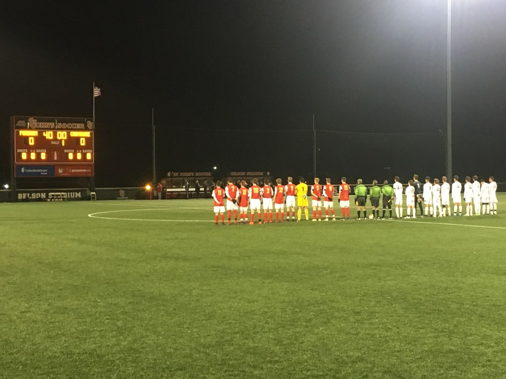 The Flyers and Rams observe the singing of the national anthem prior to kickoff.