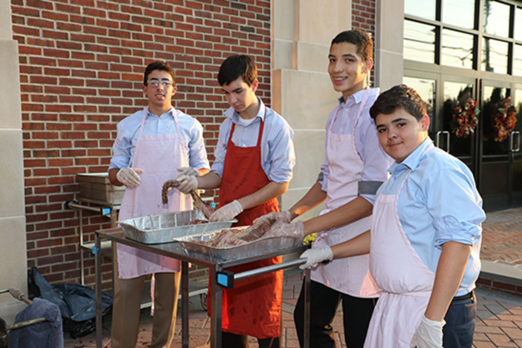 Members of the Culinary Club barbecue a steak dinner for the hungry seniors.