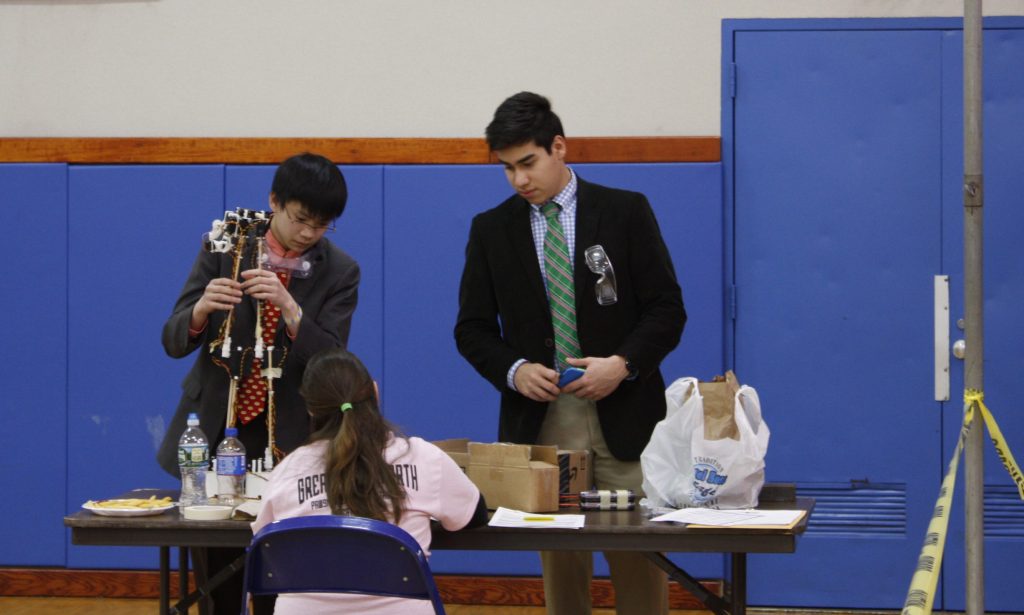 Ken Pham ’18 (left) and Pierro Salas-Allende ’18 (right) prepare their robot arm for competition. The duo finished 9th in their event. 